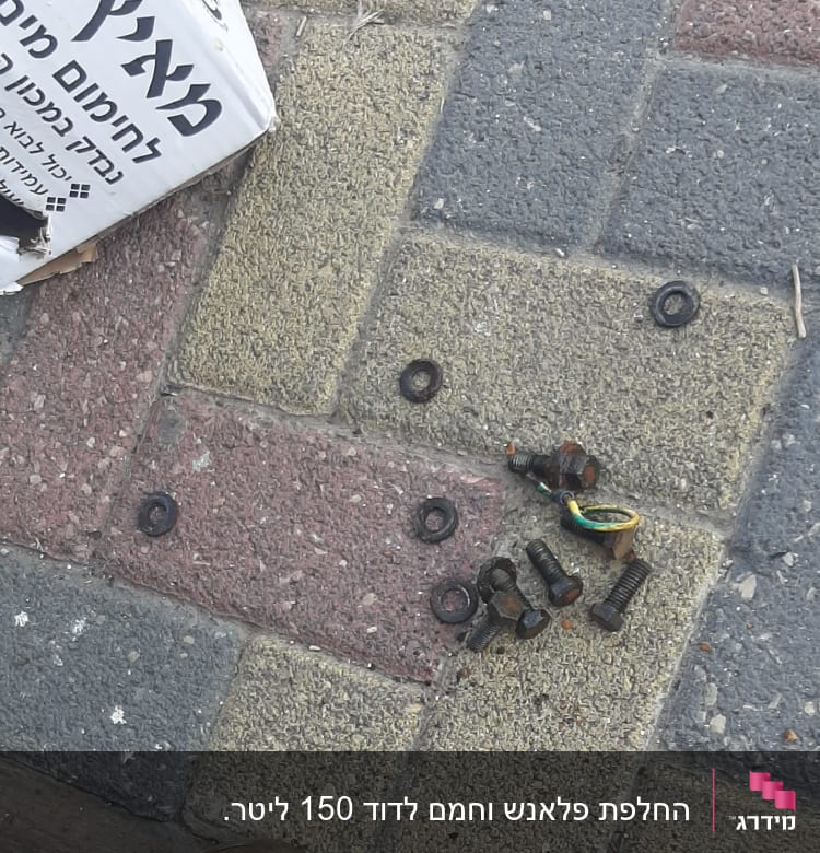 ברגים וחלקים חלודים על מדרכה